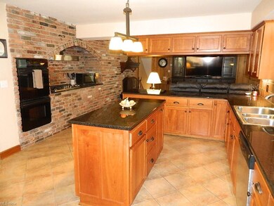 Double Ovens, Newer Gas Cooktop Surrounded by a Brick Accent Wall Leading to the Great Room ...