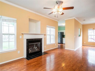 Living room with gas log fireplace and access to dining room and kitchen.