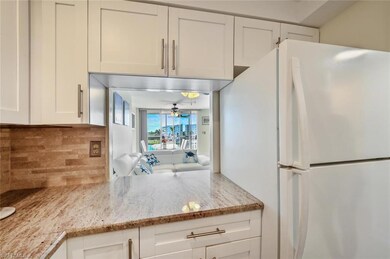 Kitchen with light stone counters, backsplash, fre