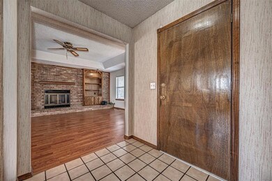 Entryway featuring a fireplace, ceiling fan, light