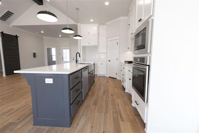 Kitchen featuring a large island with sink, white 