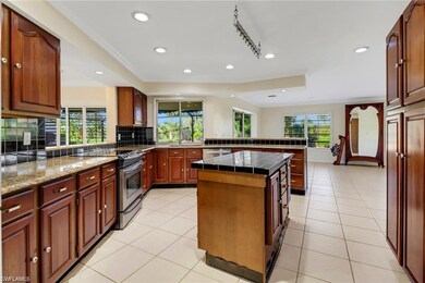 Kitchen featuring stainless steel appliances, decorative backsplash, a sink, and light tile patterned flooring