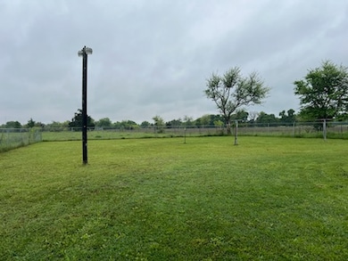 View of yard with fence and a rural view