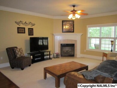 Enjoy family time in the Great Room with crown moulding, ceiling fan, and gas log fireplace.