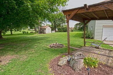 Covered brick patio shades the sun.  The shed is a