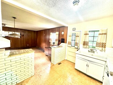 Kitchen with a textured ceiling, light tile floors