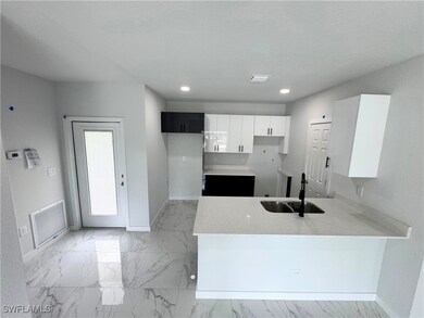 Kitchen featuring light marble finish floors, a pe