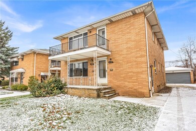 View of front of house featuring an outbuilding, a balcony, and a garage
