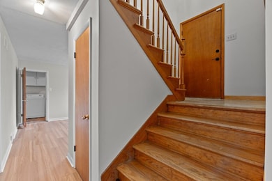 Stairs with wood finished floors and washer / dryer