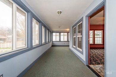 Unfurnished sunroom with baseboards and carpet floors