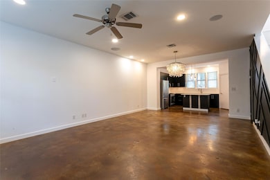 Unfurnished living room featuring a chandelier, c