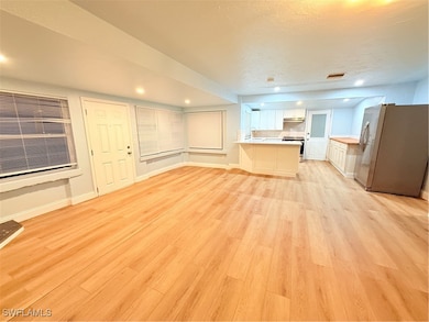 Unfurnished living room with light wood-style floo