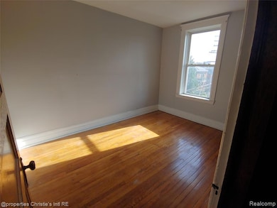Unfurnished room featuring baseboards and hardwood / wood-style floors