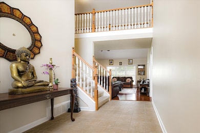Tiled foyer entrance featuring stairs and a high ceiling