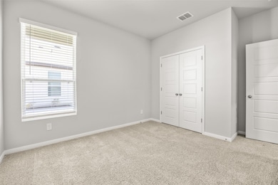 Unfurnished bedroom featuring light carpet and a closet