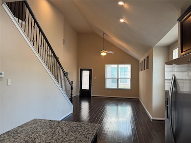 Entryway with stairway, high vaulted ceiling, dark wood-type flooring, ceiling fan, and a textured ceiling
