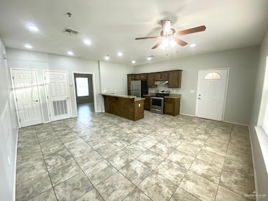 Kitchen with a ceiling fan, under cabinet range hood, recessed lighting, appliances with stainless steel finishes, and light stone countertops