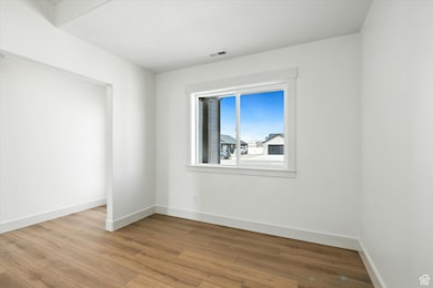 Unfurnished room featuring baseboards and light wood-type flooring
