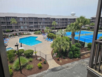 Community pool featuring fence, a patio, and a gate