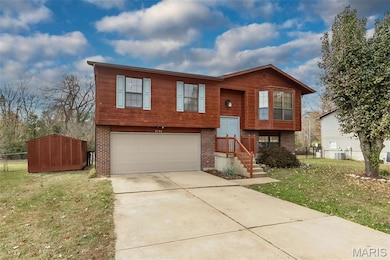 Split foyer home featuring brick siding, concrete driveway, and a garage
