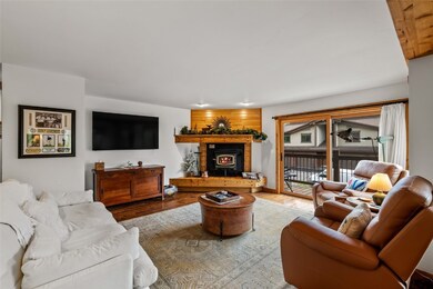 Living area with a warm lit fireplace and wood fin
