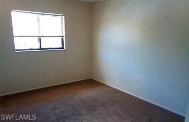 Empty room with dark colored carpet