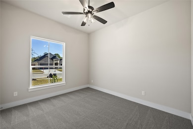 Spare room featuring carpet and a ceiling fan