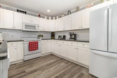 Kitchen with white cabinets, white appliances, and