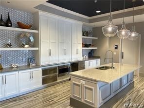 Kitchen featuring white cabinets, pendant lighting
