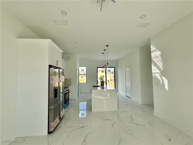 Kitchen with white cabinetry, stainless steel frid