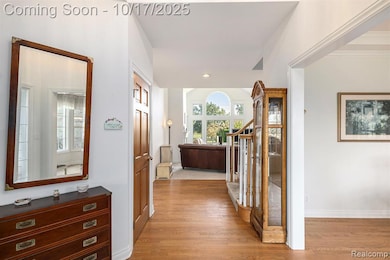 Hallway with light wood-style floors, recessed lighting, and stairs