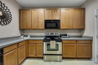 Kitchen featuring stainless steel range with electric stovetop and black microwave