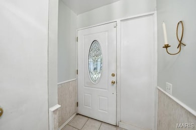 Foyer featuring a wainscoted wall and light tile patterned flooring