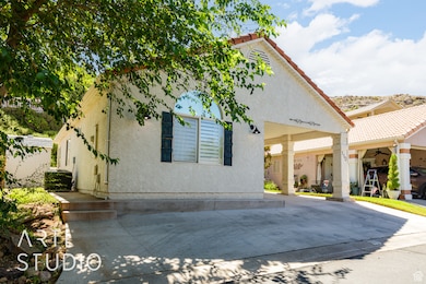 View of front of house featuring stucco siding, a tile roof, and ceiling fan