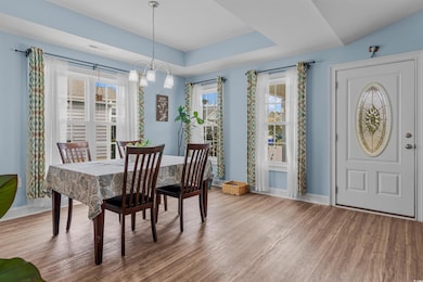 Dining area featuring a raised ceiling, wood finis