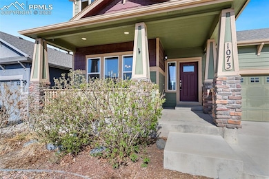 View of exterior entry featuring stone siding, cov