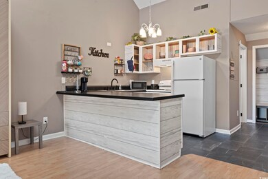 Kitchen featuring high vaulted ceiling, white appl
