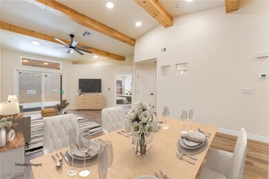 Dining space with wood finished floors, beamed cei
