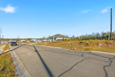 View of asphalt street featuring curbs and sidewalks