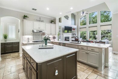 Kitchen with stone tile floors, a ceiling fan, li