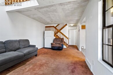 Living room featuring carpet flooring and a skylig