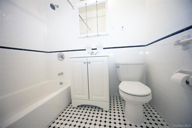 Bathroom with vanity, shower / washtub combination, tile walls, and light tile patterned flooring
