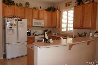 Bright sunny kitchen with corian counters , oak cabinets and plantation shutters