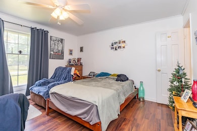 Bedroom featuring crown molding, ceiling fan, dark