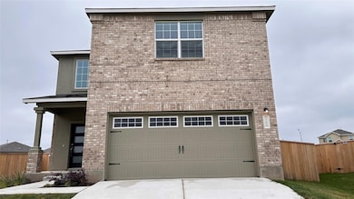 View of front of house featuring a garage, brick 