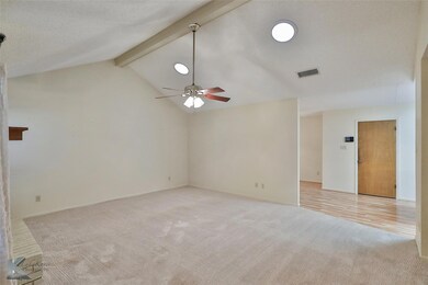 Unfurnished room featuring ceiling fan, vaulted ce