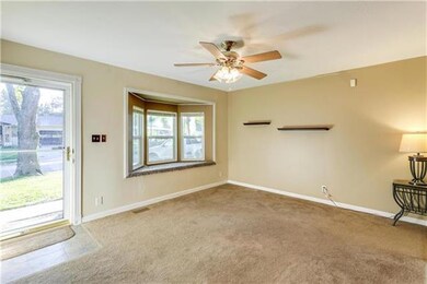 Living Room with carpet, ceiling fan and bay windo