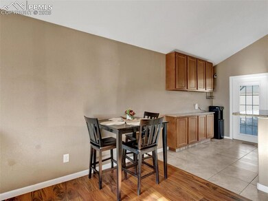 Dining area with lofted ceiling and light hardwood