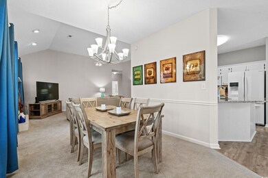 Carpeted dining area with an inviting chandelier, 