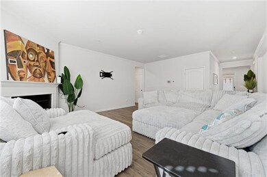 Living area featuring wood finished floors, crown molding, and a fireplace